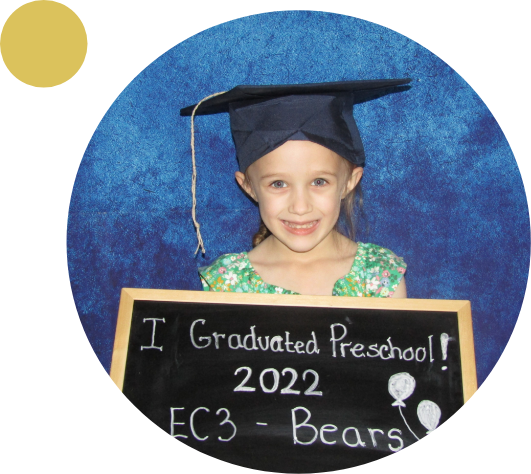 Young girl holding a graduation sign