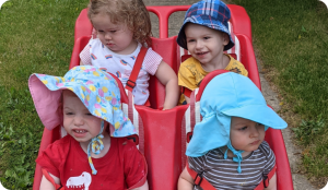 4 toddlers in a play car